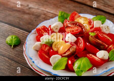 Gustosa insalata a base di pomodori ciliegini, mozzarella e basilico. Primo piano. Foto Stock