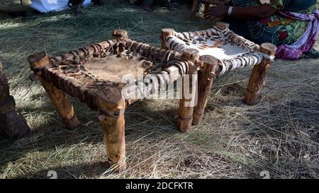 Sgabelli tradizionali in legno e pelle su pavimento in paglia Foto Stock