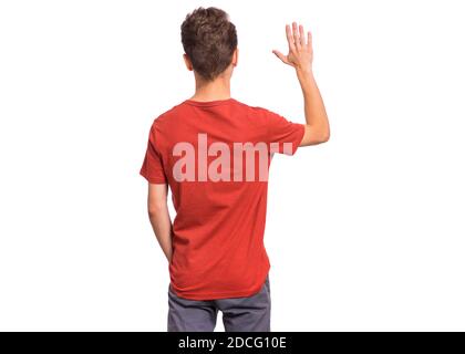 Bel ragazzo teenager con la schiena girata alla macchina fotografica, indicando qualcosa, isolato su sfondo bianco Foto Stock