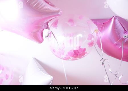 Palloncini rosa, bianchi e trasparenti con petali di rosa gonfiati con elio  su sfondo bianco Foto stock - Alamy