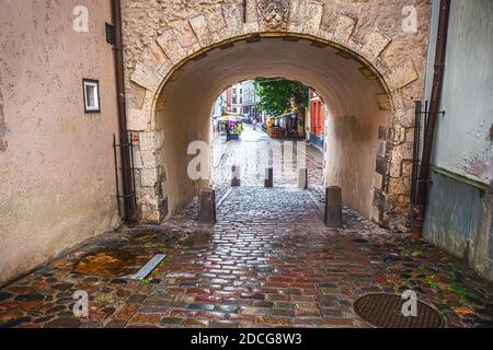 Vecchia strada acciottolata e casa con arco nel centro di riga, Lettonia. Foto Stock