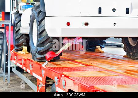 Fissaggio di carichi pesanti con una cinghia di ancoraggio sulla piattaforma di trasporto, spazio di copia. Foto Stock