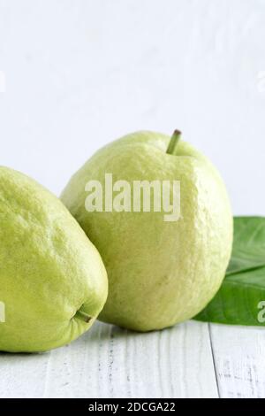 Primo piano di deliziosa bella guava rossa con foglie fresche di verde isolato su sfondo bianco tavolo, studio di ripresa con spazio copia. Foto Stock