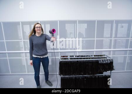 Ingegnere di prova asciugacapelli i laboratori di capelli di Dyson a Malmesbury, Wiltshire, Regno Unito. Foto Stock