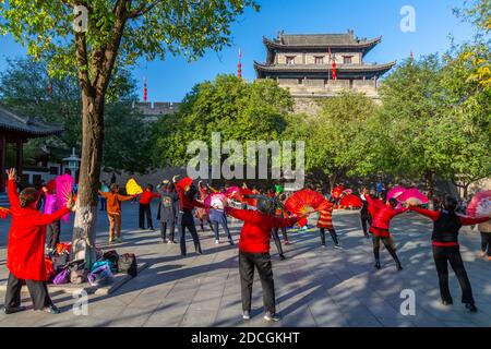 Locali che eseguono Tai chi vicino alle mura della città di Xi'an, provincia Shaanxi, Repubblica Popolare Cinese, Asia Foto Stock