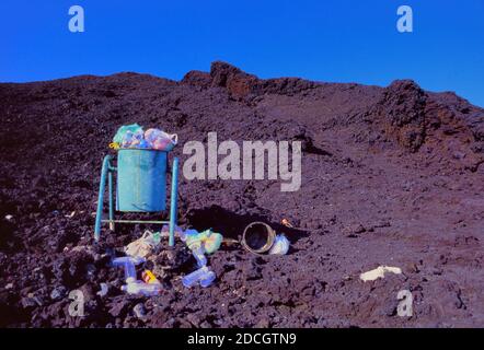 Traboccante cestino spazzatura, lettiera o immondizia lasciato da turisti o camminatori in cima al vulcano Piton de l'Fournaise & Lava Rock o montagna picco a la Reunion o Reunion Island Francia Foto Stock