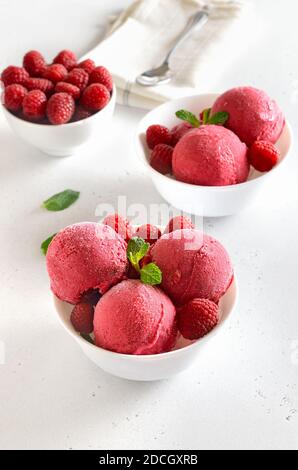 Paletta di gelato al lampone fatta in casa con lamponi freschi in una ciotola bianca. Dessert estivo freddo Foto Stock