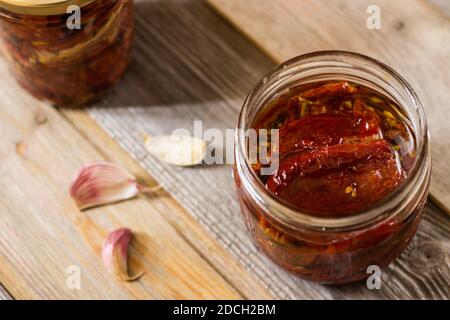 Pomodori secchi in vaso con olio extravergine d'oliva, origano e aglio. Messa a fuoco selettiva Foto Stock