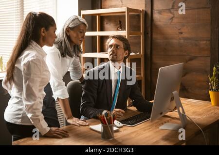 Team aziendale multietnico di giovani che lavorano al progetto durante la riunione aziendale, diversi dipendenti condividono idea con i colleghi nuovi aggiornamenti che ha fatto Foto Stock