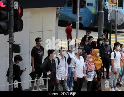 Hong Kong, Cina. 21 Nov 2020. I pedoni che indossano maschere facciali aspettano di attraversare una strada a Hong Kong, Cina meridionale, 21 novembre 2020. PER ANDARE CON 'le infezioni giornaliere di Hong Kong COVID-19 hanno colpito 3 mesi di alta' Credit: Li Gang/Xinhua/Alamy Live News Foto Stock