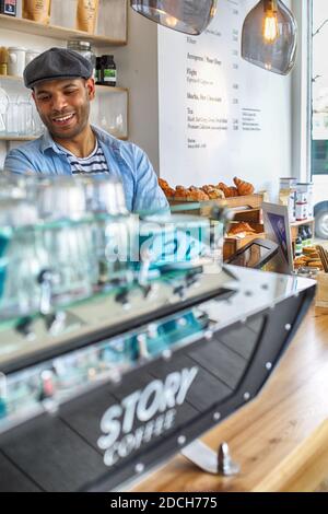 Barista che prepara una tazza di caffè per il cliente in caffetteria. Foto Stock