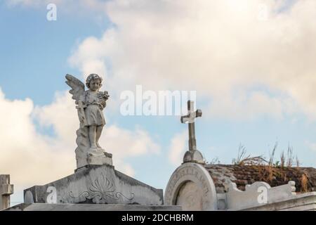Statua di un angelo che tiene fiori su una tomba nel cimitero di lafayette a New Orleans, Louisiana Foto Stock