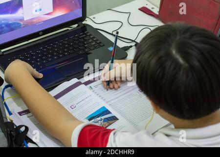 Un ragazzo che ascolta la musica mentre studia. Foto Stock