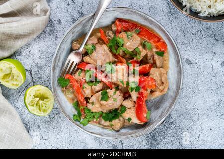 Pollo indonesiano in salsa al burro di arachidi con peperoni rossi e. coriandolo - vista dall'alto Foto Stock