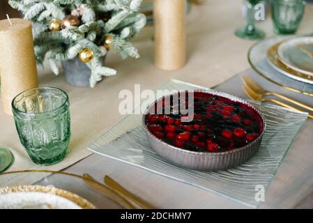 Torta di frutti di bosco fatta in casa per Natale o Capodanno sullo sfondo del tavolo delle feste. Il concetto di dessert festosi. Il cibo è delizioso. Foto Stock