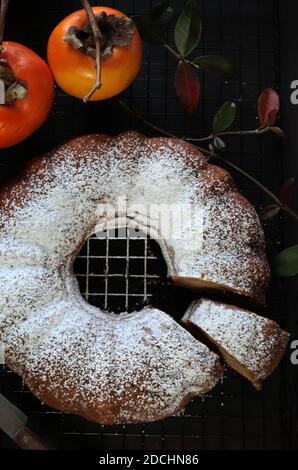 Torta di persimmon al cioccolato fatta in casa con zucchero in polvere. Sfondo scuro Foto Stock