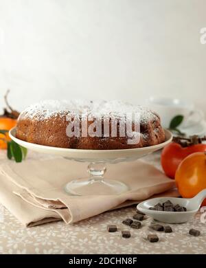 Torta di persimmon al cioccolato con zucchero in polvere. Cottura a casa. Messa a fuoco selettiva. Foto Stock