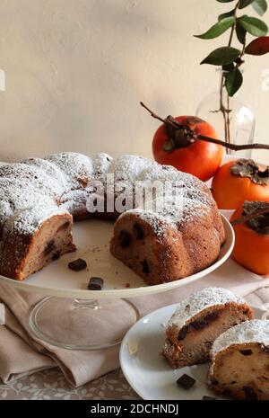 Torta di persimmon al cioccolato con zucchero in polvere. Cottura a casa. Messa a fuoco selettiva. Foto Stock