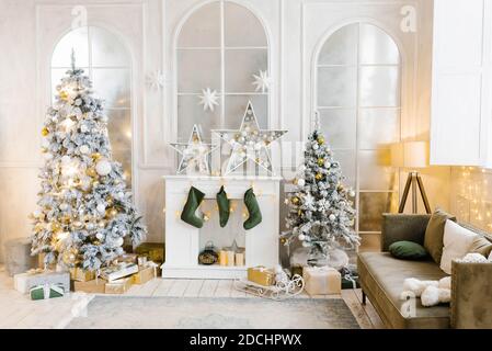 Luminoso e accogliente soggiorno con un grande ed elegante albero di Natale, decorato per Natale Foto Stock