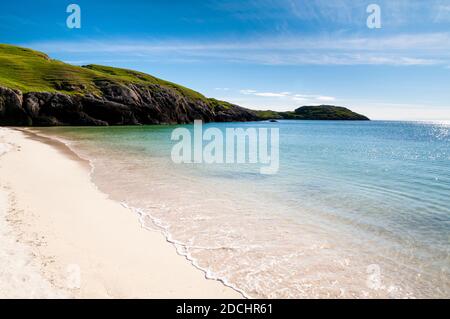 Una vista di una spiaggia di sabbia bianca sulla riva della Baia di Achmelvich, nell'estremo nord della Scozia. Giugno. Foto Stock