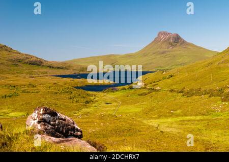 Una vista della montagna frastagliata Stac Pollaidh con Loch Lurgainn in primo piano, nel nord-ovest della Scozia. Giugno. Foto Stock