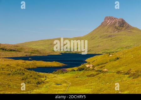 Una vista della montagna frastagliata Stac Pollaidh con Loch Lurgainn in primo piano, nel nord-ovest della Scozia. Giugno. Foto Stock