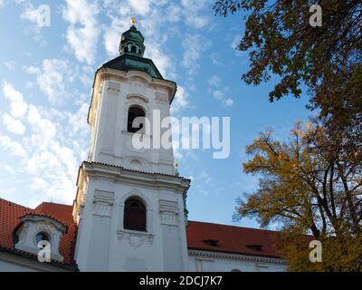 Il campanile del Monastero di Strahov contro il cielo blu in autunno. Foto Stock