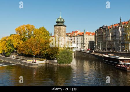 Antica torre sulla riva del fiume in autunno. Autunno Praga. Orizzontale. Foto Stock