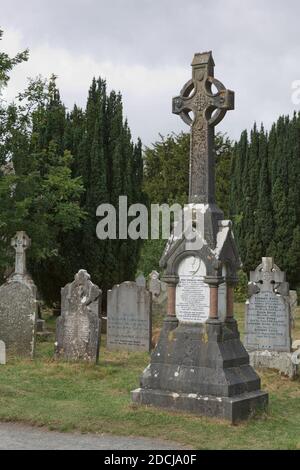 Glendalough, co. Wicklow, Irlanda - Agosto 10 2019 :Torre rotonda in pietra e alcune rovine di un insediamento monastico originariamente costruito nel VI secolo in G. Foto Stock