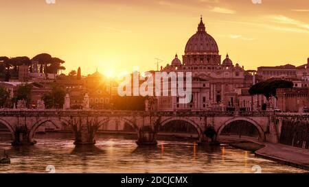 Roma al tramonto, Italia. Vista panoramica soleggiata della Basilica di San Pietro nella Città del Vaticano, famoso punto di riferimento di Roma. Panorama del fiume Tevere e della vecchia Roma in pari Foto Stock