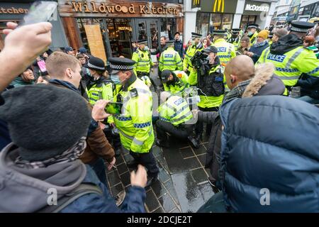 Church St, centro di Liverpool, 21 novembre 2020: Le folle si riuniscono durante una protesta anti-blocco. Un uomo è detenuto mentre gli onlookers si riuniscono. Polizia, Regno Unito Foto Stock