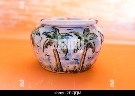 Bella pittura di palma in ceramica fatta a mano Ashtray su sfondo astratto giallo gradiano per decorazione di casa. Foto Stock