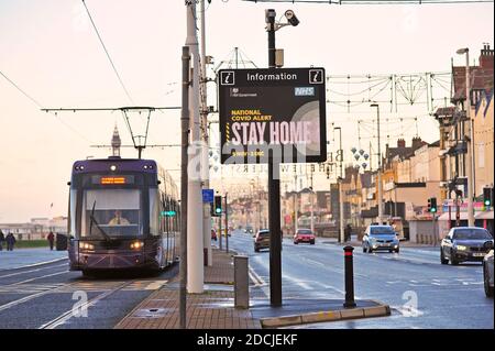 Traffico stradale che passa National Covid Alert segnale elettronico tra principale strada e tram Foto Stock