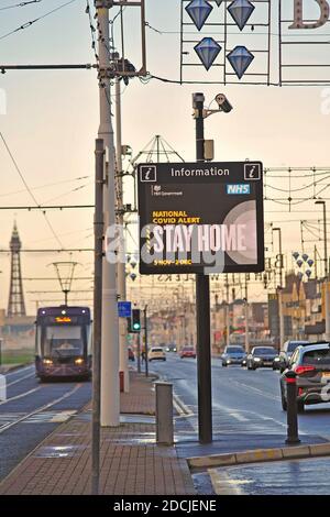 Traffico stradale che passa National Covid Alert segnale elettronico tra principale strada e tram Foto Stock