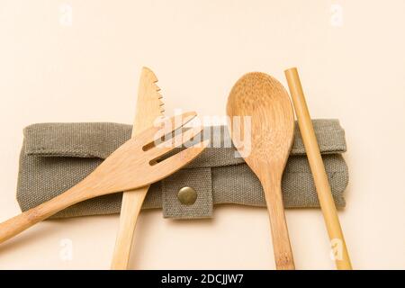 Set di posate eco-friendly di bambù su sfondo color cammello. Concetto privo di plastica. Primo piano, vista dall'alto. Foto Stock