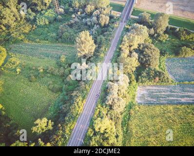 Vista dall'alto della ferrovia che corre alla periferia della città di Zagabria, lungo l'area boschiva e i campi agricoli, fotografati con il drone Foto Stock