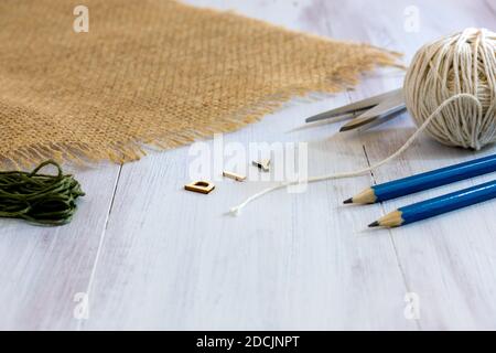 Lettere di legno di DIY, fallo voi stessi con matite, forbici, fili e burlap su sfondo di legno con spazio di copia Foto Stock