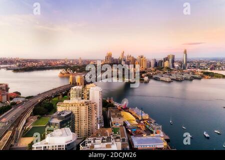 I punti di riferimento del CBD della città di Sydney dall'altra parte del porto, dalla baia di Lavender alle Rocks e alla banchina circolare all'alba. Foto Stock