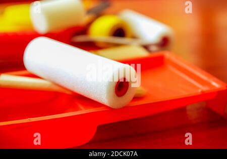 Attrezzi per la riparazione a domicilio. Rulli in schiuma per colorazione parete in contenitore di plastica primo piano. Foto Stock