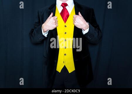 Ritratto di Fancy vestito uomo in giacca Velvet e gilet giallo con mani su revers. Stile ed eleganza sartoriali. Sposo il giorno del matrimonio Foto Stock