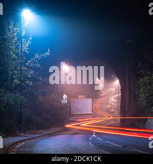 Il traffico lascia sentieri leggeri sotto il Viadotto di Royate Hill in una notte nebbiosa a Eastville, Bristol. Foto Stock