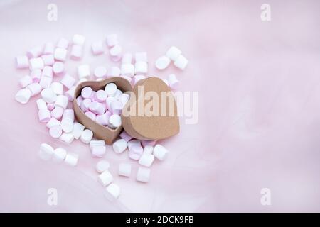 Marshmallow rosa in scatola regalo a forma di cuore su fondo tessile, molti marshmallows per il presente, amore dolce. San Valentino. Spazio di copia. Foto. Foto Stock