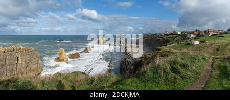 Un panorama di una costa rocciosa e selvaggia con tempesta onde che colpiscono la riva Foto Stock