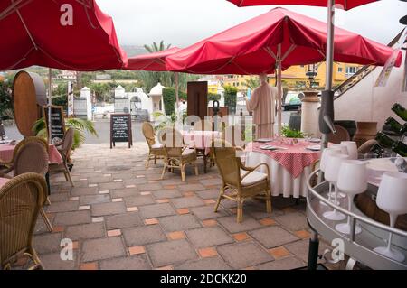 Caffetteria estiva con tavoli sotto gli ombrelloni senza visitatori a Tenerife. Spagna. Foto Stock