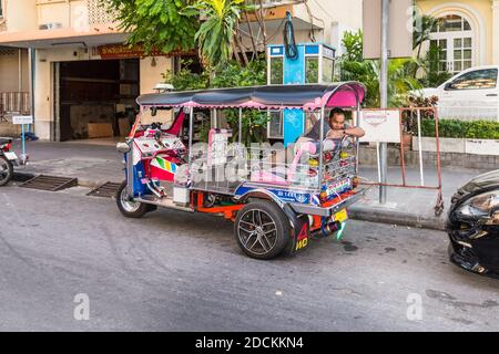 Bangkok, Thailandia - 7 dicembre 2019: Autista di tuk-tuk che dorme nel suo veicolo prima che il prossimo cliente salti per le strade di Bangkok, Thailandia. Foto Stock