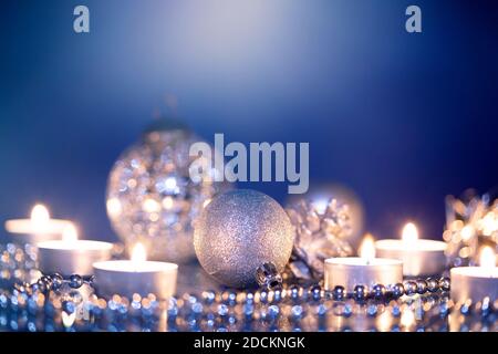 Palline di Natale d'argento su sfondo scintillante di festa. Luci magiche per le vacanze. Buon Natale e felice anno nuovo Foto Stock