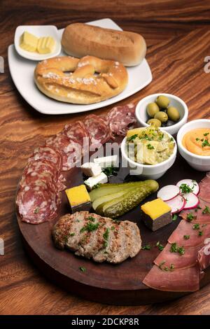 piatto di tapas a base di salumi tedeschi con carne e pane su sfondo tavola di legno Foto Stock