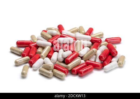 Primo piano di una pila di pillole o capsule in diversi colori su sfondo bianco isolato. Integratori alimentari sotto forma di pillole o capsule. Foto Stock