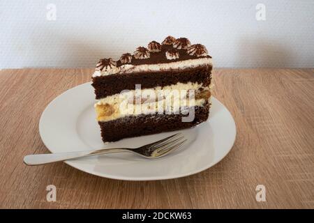 Fetta di torta tiramisù decorata con panna montata e cioccolato polvere Foto Stock