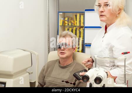 Donna medico oftalmologo controlla la visione di un uomo in un ufficio medico. Medico e paziente in una clinica oftalmologica. Test di visione